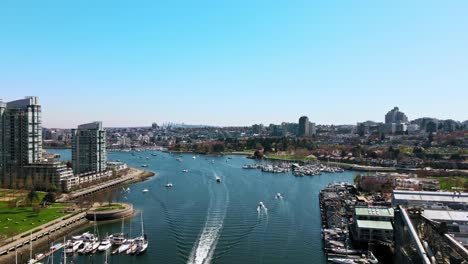 Impresionante-Antena-Del-Puerto-Con-Barcos-En-Un-Ajetreado-Canal-A-Lo-Largo-Del-Paisaje-De-La-Ciudad---Cámara-Lenta