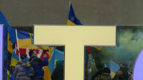 Ukrainian-flags-and-smoke-at-anti-war-protest-in-Toronto,-handheld