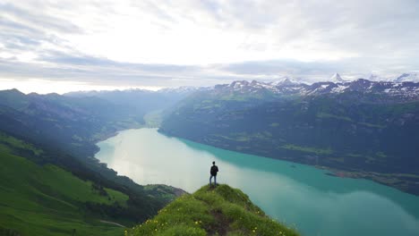 Männlicher-Wanderer-Am-Aussichtspunkt-über-Dem-Brienzersee,-Atemberaubende-Aussicht-Auf-Die-Verschneiten-Alpen