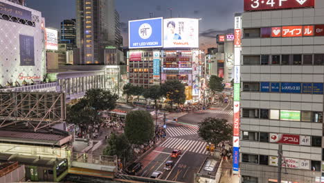 Tren-Jr-En-La-Estación-De-Shibuya-Con-Vista-Al-Cruce-De-Shibuya-Scramble-Por-La-Noche-Con-Tráfico-Y-Peatones-En-Tokio,-Japón