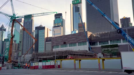 Hong-Kong-Cityscape,-Cranes-on-New-Real-Estate-Construction-Site,-Street-Traffic-and-Downtown-Skyscrapers,-Wide-View