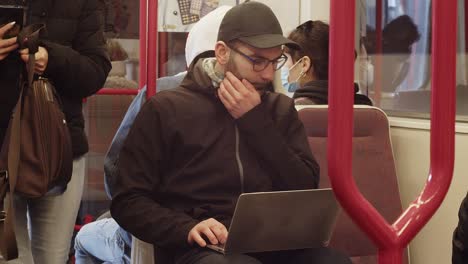 Los-Pasajeros-Bajan-Del-Tren-Pasando-A-Un-Hombre-Caucásico-Con-Una-Computadora-Portátil