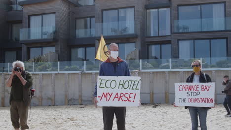 Los-Manifestantes-Locales-Sostienen-Carteles-De-Indignación-Ecológica-Frente-A-La-Playa-Del-Hotel-Carbis-Bay,-Ubicación-Para-La-Cumbre-Del-G7,-Cornualles