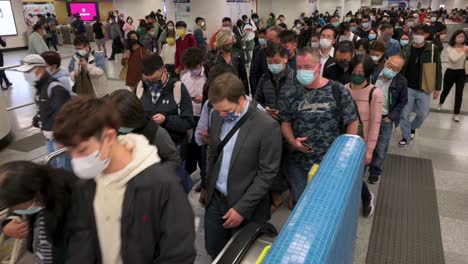 Commuters-wearing-face-masks-as-prevention-again-the-Coronavirus-epidemic-outbreak,-officially-known-as-Covid-19,-are-seen-riding-on-an-escalator-during-rush-hour-at-the-subway-station-in-Hong-Kong