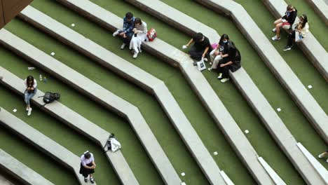 Pov-Al-Parque-Público-De-Escaleras-Mientras-Mucha-Gente-Se-Relaja-En-El-Día-De-Verano