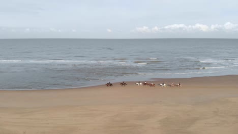 Tourists-Riding-On-Horses-At-Sandy-Beach-In-The-North-Sea-Near-Katwijk-And-Noordwijk-In-South-Holland,-Netherlands