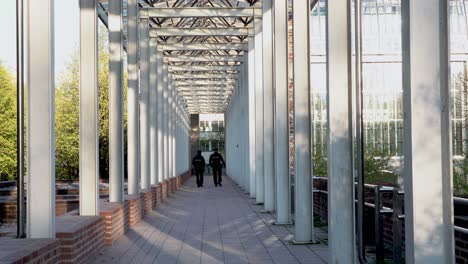 Two-German-police-officers-walking-along-a-foot-path-near-the-Bavarian-State-Chancellery-and-talking-to-each-other