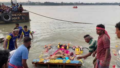 Kolkata,-West-Bengal,-India-October-14,2021--Unidentified-group-of-people-submerge-the-statue-of-Maa-Durga-on-the-day-of-bijoya-dosomi,-in-the-Ganges-river