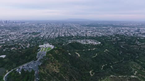 Toma-Aérea-Del-Observatorio-Griffith-Con-Vistas-A-Los-ángeles-Y-Hollywood-En-Un-Día-Nublado,-Rutas-De-Senderismo-Debajo