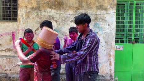 Kolkata,-Bengala-Occidental,-India---03-31-2022:-Grupo-De-Niños-Alegres-Con-Cubo-De-Color,-Pichkari-Gritando-A-La-Cámara-Después-De-Jugar-Con-Polvo-De-Holi-Colorido-Durante-La-Celebración-Del-Festival