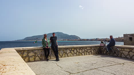 Trapani,-Sizilien,-Italien:-Blick-Auf-Ein-Paar,-Das-Zusammen-Mit-Den-Einheimischen-Am-Strand-Der-Altstadt-Von-Trapani-Mit-Blick-Auf-Das-Meer-Fotos-Macht