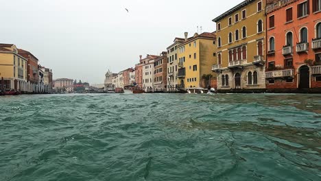 Punto-De-Vista-De-La-Superficie-Del-Agua-De-ángulo-Bajo-De-Venecia-Y-Lancha-Motora-Que-Pasa-Vista-Desde-El-Barco-De-Navegación,-Venecia-En-Italia