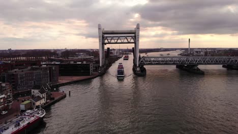 Vista-Aérea-Del-Buque-De-Carga-Alphenaar-Pasando-Lentamente-A-Través-Del-Puente-Ferroviario-Elevado-Spoorbrug