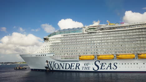 Drone-shot-of-the-Wonder-Of-The-Seas-Royal-Caribbean-cruise-ship-docked,-rotating-and-zooming-out