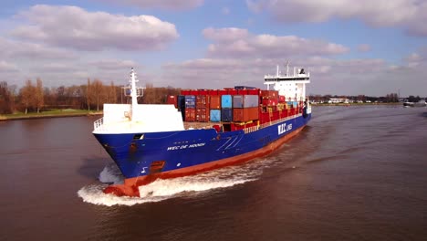 Aerial-Circle-Dolly-Around-Forward-Bow-Of-WEC-de-Hoogh-Cargo-Ship-Along-Oude-Maas