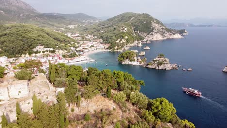 Crucero-Navega-Hacia-El-Pintoresco-Pueblo-Costero-De-Parga-En-Epirus,-Grecia---Antena