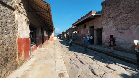 Dolly-Vorwärts-Spaziergang-Zwischen-Alten-Straßen-In-Pompeji-Mit-Ruinen-Und-Historischen-Gebäuden-Im-Sommer---Touristen-Genießen-Sightseeing-Reise-In-Italien