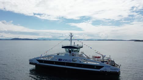 Volando-En-Círculos-De-Cerca-A-Lejos-Alrededor-Del-Ferry-De-Pasajeros-Norled-Noruego-Con-Banderas-De-Señales-Barcos-Vistiendo