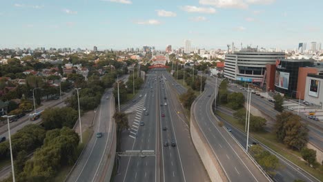 Aerial-dolly-in-of-General-Paz-Avenue-traffic-at-daytime-with-DOT-Baires-shopping-beside