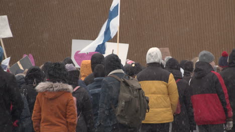 Medium-wide-shot-of-a-group-of-protesters-standing-together-with-flags-and-placards-at-the-Helsinki-Covid-protests