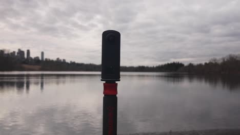 360-Grad-Kamera-Auf-Einem-Einbeinstativ-Am-Rande-Eines-Sees,-Die-Landschaftsfotografie-Und-Videografie-Von-Wasser,-Wolken,-Bäumen-Und-Himmel-Aufnimmt