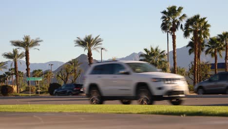 Autoverkehr-Auf-Der-Von-Palmen-Gesäumten-Avenue,-La-Quinta,-Vororte-Von-Kalifornien-Im-Sonnenschein