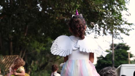 Junges-Mädchen-Mit-Langen-Braunen-Haaren-Von-Hinten-Mit-Weißem-Kleid,-Flügeln-Und-Einem-Einhornhorn