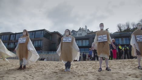 Los-Manifestantes-Hacen-Fila-En-La-Playa-Para-Protestar-Contra-La-Caída-Ecológica-Del-Hotel-Carbis-Bay,-Cornwall.