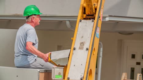 An-old-worker-controlling-a-crane-in-the-sun