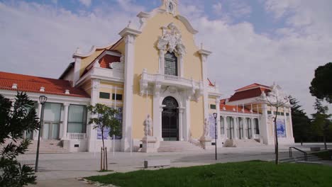 Ancient-and-well-preserved-colourful-building-in-front-of-a-park-with-statues-in-front-of-it-and-decorative-tiles