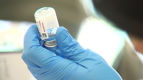 Nurse-holds-Astra-zeneca-covid-vaccine-bottle-in-hands,-closeup