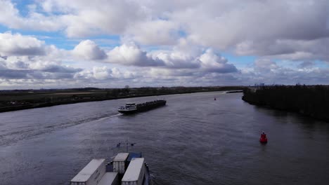 Cargo-Ship-Loaded-With-Intermodal-Containers-Cruising-At-Oude-Maas-River-In-Puttershoek,-South-Holland,-Netherlands