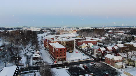 AERIAL-Over-Historic-Brick-Factory-Building-During-Snowstorm,-USA