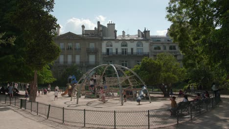 Schwenk-über-Den-Spielplatz-Mit-Kindern,-Die-An-Einem-Sonnigen-Tag-Im-Parc-Monceau-In-Paris,-Frankreich,-Auf-Der-Kletterkuppel-Spielen