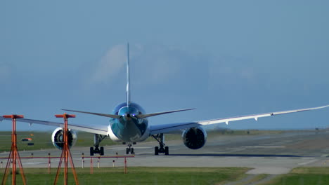 Un-Avión-De-Fuselaje-Ancho-Y-Largo-Recorrido-Alineado-En-La-Pista,-Día-Soleado