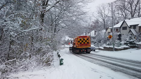 Totale-Aufnahme-Eines-Schneepfluges,-Der-Einen-Hügel-In-Einem-Wohnviertel-Salzt