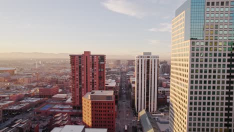 Vista-Aérea-De-Drones-Del-Centro-De-Denver-Colorado-Volando-Hacia-Atrás-Mostrando-La-Torre-Del-Reloj-De-Lannies-En-La-Calle-Arapahoe-Durante-La-Puesta-De-Sol-De-La-Hora-Dorada