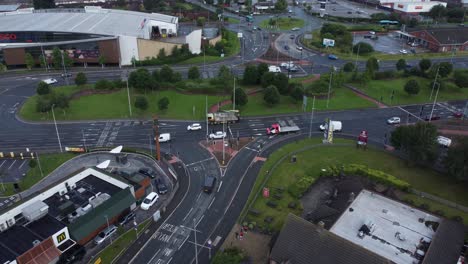 Aerial-view-above-busy-British-shopping-retail-car-park-store-traffic-shops-slow-left-dolly