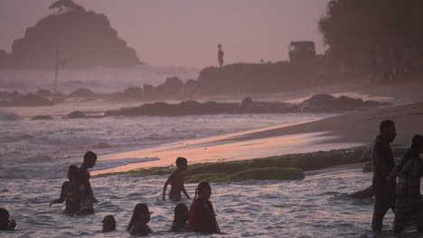 People-splash-in-the-ocean-at-sunset-during-the-golden-hour