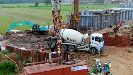 Excavadoras-Y-Máquinas-De-Cemento-Trabajando-En-Un-Proyecto-De-Monorraíl-En-Kulon-Progo,-Vista-Aérea