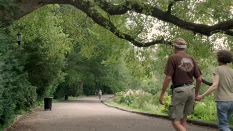 Couple-Holds-Hands-In-New-York-City's-Fort-Tryon-Park-On-A-Summer-Day