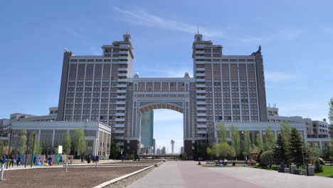 Gimbal-shoot:-tourist-Walk-through-modern-building-in-the-residential-district-of-the-city-center-revealing-modern-skyline-of-the-capital-during-a-sunny-day