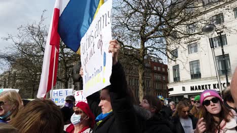 Patriotic-female-with-Putin-message-at-Ukraine-anti-war-protest-activists-on-Manchester-city-street