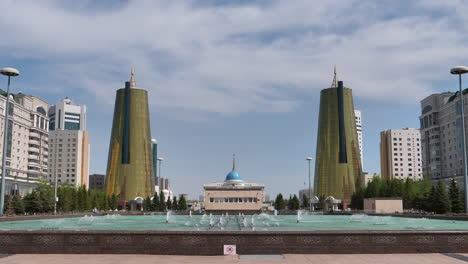 Tiro-Estático-Gran-Plaza-De-La-Fuente-De-Agua-De-Ak-Orda-La-Residencia-Del-Presidente-De-La-República-De-Kazajstán-En-El-Centro-De-La-Ciudad-De-La-Capital-Con-Dos-Famosos-Rascacielos-Torre-Dorada