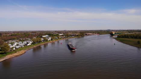 Aerial-Drone-View-Da-Vinci-Motor-Tanker-Ship-In-Distance-Approaching-Along-Oude-Maas