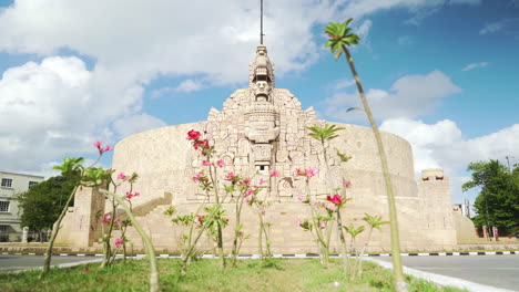 Homeland-monument-roundabout-in-downtown-MÃ©rida,-Mexico-with-pink-flowers-and-traffic