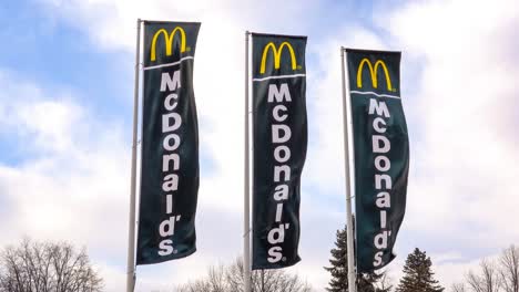 Tres-Pancartas-Negras-De-Mcdonalds-De-Una-Cadena-De-Restaurantes-De-Comida-Rápida-Ondeando-En-Un-Fuerte-Viento