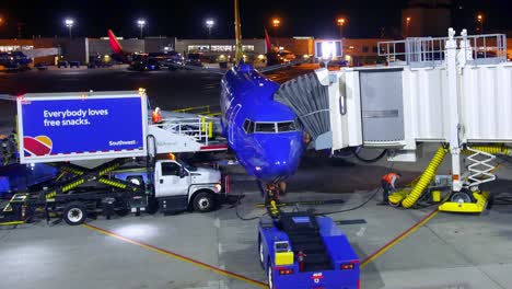 Lapso-De-Tiempo-Del-Atraque-Del-Avión-De-Las-Aerolíneas-Del-Suroeste-Con-Control-De-Tráfico-Aéreo-Descargando-Equipaje-Y-Llenando-Bocadillos-Por-Parte-De-La-Tripulación-De-Tierra-En-La-Terminal-Del-Hangar-En-El-Aeropuerto-1