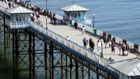 Visitantes-Turísticos-Caminando-Por-El-Paseo-Marítimo-Del-Muelle-De-Llandudno-Atracción-Histórica-Soleada-En-Vacaciones-Galesas