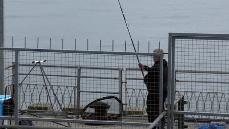 Einsamer-Mann-Angelt-In-Einem-Geschlossenen-Metallhafen-Am-Meer-Und-Bereitet-Ausrüstung-Vor